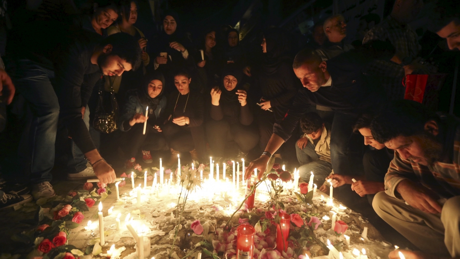 Beirut residents light candles during a vigil at the site of the two explosions that occurred on Thursday in the southern suburbs of the Lebanese capital Beirut, Credit: Hasan Shaaban/Reuters