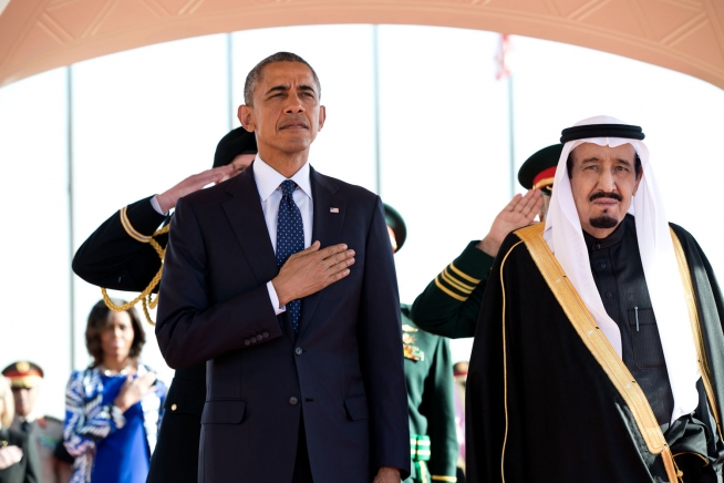 President Obama and King Salman Arabia stand at attention during the U.S. national anthem as the First Lady stands in the background with other officials on Jan. 27, 2015, at the start of Obama’s State Visit to Saudi Arabia. (Official White House Photo by Pete Souza)
