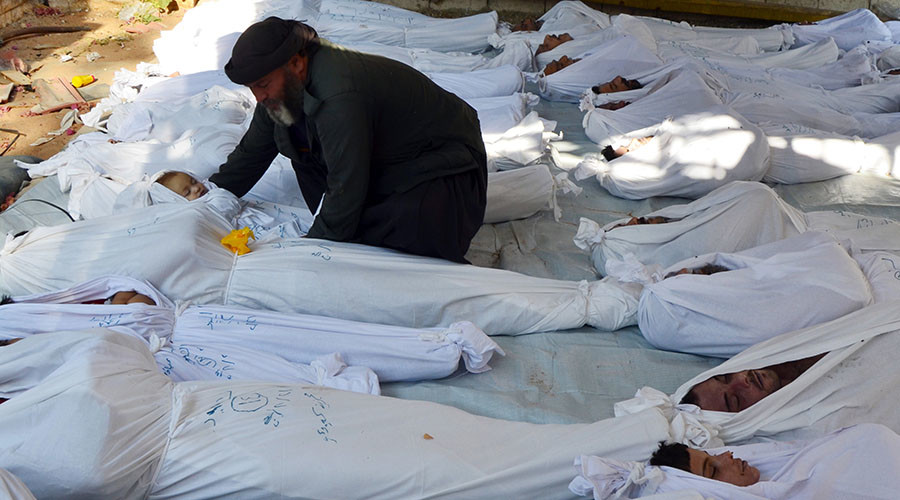A man holds the body of a dead child among bodies of people activists say were killed by nerve gas in the Ghouta region, in the Duma neighbourhood of Damascus August 21, 2013. © Bassam Khabieh / Reuters