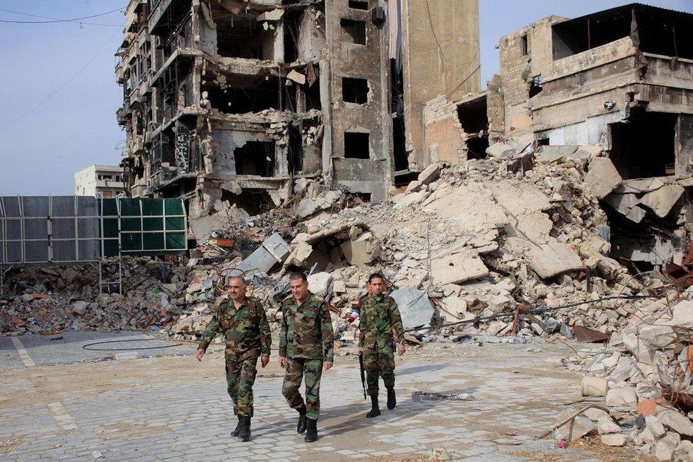 Syrian army soldiers walk through government-held Aleppo in 2015 (AFP)