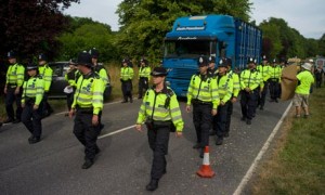 Police escort a lorry containing drilling equipment