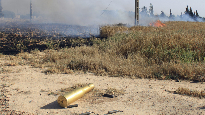 An empty ammunition casing and a fire are seen in a field after heavy fighting between Free Syrian Army fighters, and the forces of Syrian President Bashar al-Assad and Lebanon's Hezbollah at the al Barak area near Qusair town May 31, 2013. (Reuters)