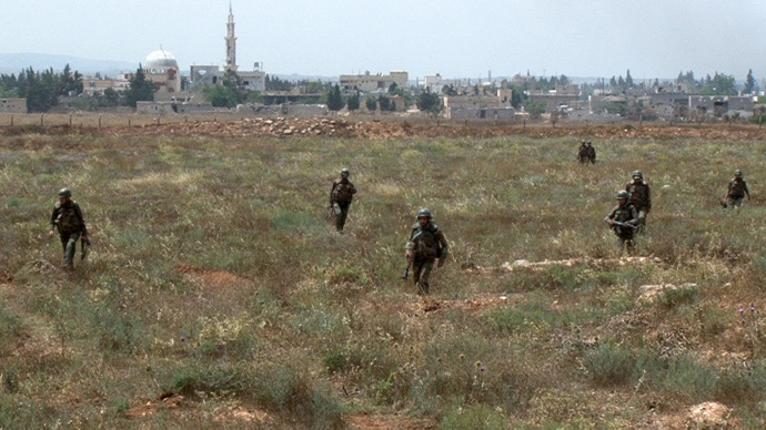 A handout picture released by the Syrian Arab News Agency (SANA) on May 30, 2013, shows Syrian army soldiers walking nearby facilities of Dabaa military airfield during an operation that led to the control of the airport, north of the Syrian city of Qusayr. (AFP Photo / SANA)