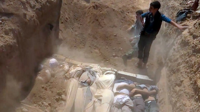 An image grab taken from a video uploaded on YouTube by the Local Committee of Arbeen on August 21, 2013 allegedly shows Syrians covering a mass grave containing bodies of victims that Syrian rebels claim were killed in a toxic gas attack by pro-government forces in eastern Ghouta and Zamalka, on the outskirts of Damascus. (AFP Photo)