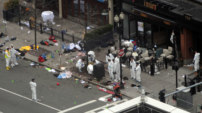 Investigators in white jumpsuits work the crime scene on Boylston Street following yesterday's bomb attack at the Boston Marathon April 16, 2013 in Boston.(AFP Photo / Darren McCollester)
